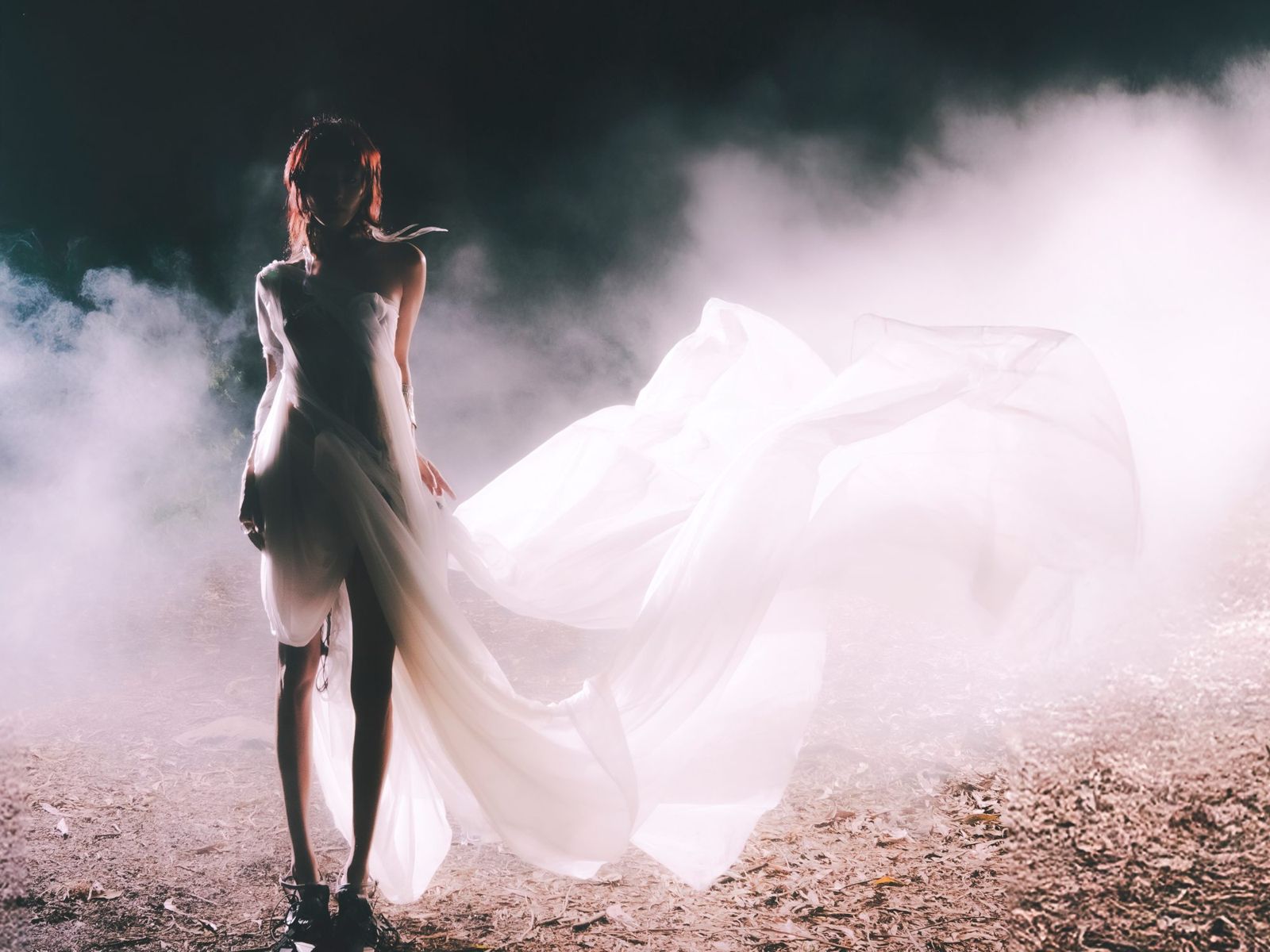 Backlit figure in fog with a billowing white train